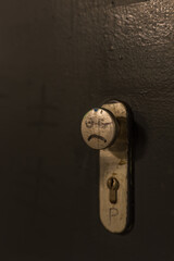 A doorknob with a bad tempered face painted on it