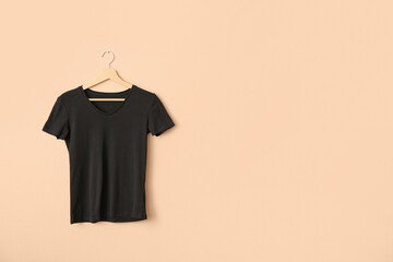 Black t-shirt hanging on light wall