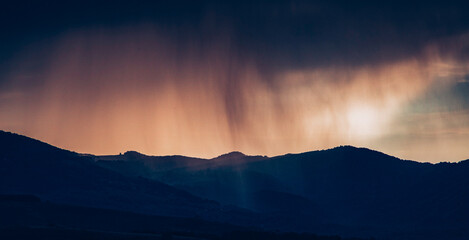 banner of mountain peaks in beautiful stormy sunset light