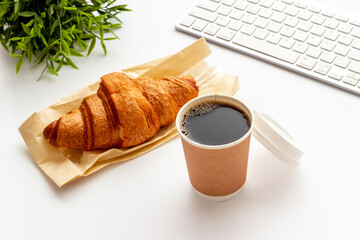 Takeaway coffee in paper cup with croissant. Coffee break background