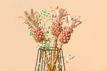 Vase with decorative pineapples on beige background, closeup