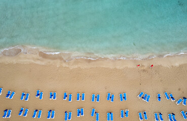 Drone aerial of beach chairs in a  tropical sandy beach. Summer holidays in the sea. Protaras Cyprus Europe
