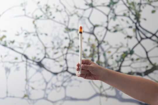 Woman holds lighted ear wax candle. Ear wax removal method. 