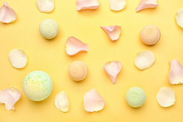 Bath bombs with floral petals on yellow background
