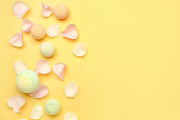 Bath bombs with floral petals on yellow background