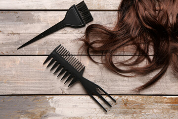 Brown hair with brushes on wooden background