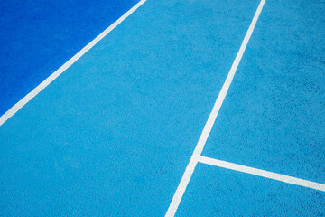 Fototapeta na wymiar Sport field court background. Light blue rubberized and granulated ground surface with white lines. Top view