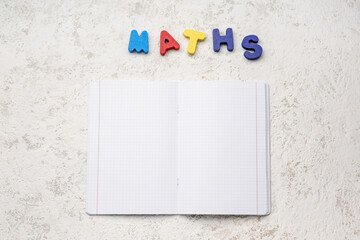 Blank copybook pages and text MATHS on white grunge background