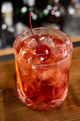 Negroni alcoholic cocktail in the glass close-up. Bartender prepares traditional Negroni cocktail at the bar.
