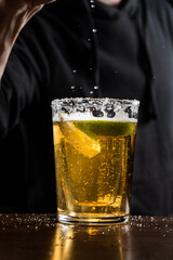 Bartender squeezes lime and sprinkles juice over the Death of Mexican alcoholic cocktail with shot...