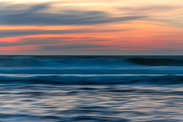 Fototapeta na wymiar Red sunset over the sea, abstract seascape background in bright red-pink and blue colors, design, motion blur