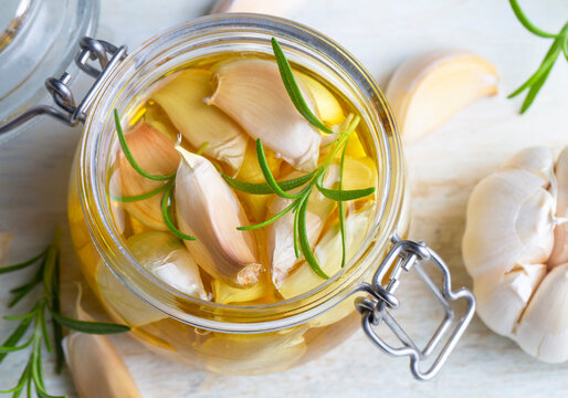 Fresh garlic and garlic oil on the wooden background