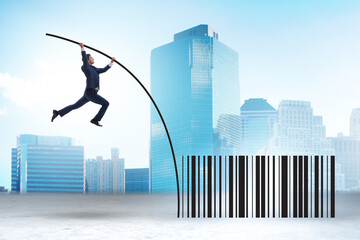 Businessman jumping over bar code in pole vaulting