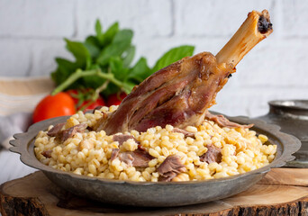 Turkish foods; lamb shank tandoori on bulgur wheat rice (Turkish name; bulgur bugday pilavi kuzu incik tandir)