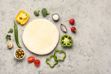 Raw dough and ingredients for preparing vegetable pie on grey grunge background