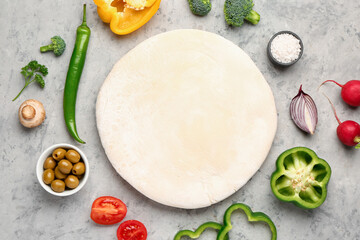 Fototapeta na wymiar Raw dough and ingredients for preparing vegetable pie on grey grunge background