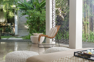 Half opened lounge area with all natural materials made furniture, rattan chairs with greenery...