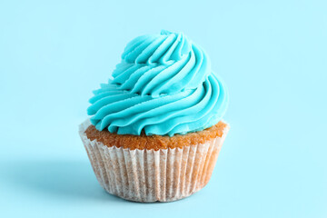 Tasty cupcake on blue background