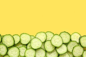 Slices of cucumber on yellow background