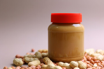 peanut butter and raw peanuts on a colored background