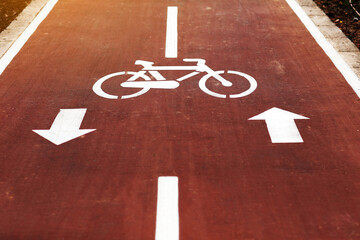 New marking bike path. White bicycle symbol and two oposite arrows on red asphalt lane, road....