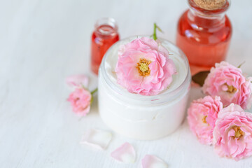 Premium skin care beauty treatment with pink rose petals. Plant-based pure organic ingredients in cosmetics. Jar of body or face moisturiser, lotion. Flower extract, natural youth anti-age elixir