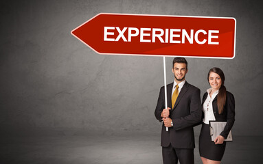 Young business person in casual holding road sign