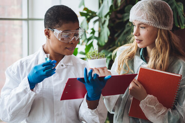 Two female scientists working in the laboratory making biological test, scientific research. Concept of multicultural multiethnic multiracial people in science, professional biologist