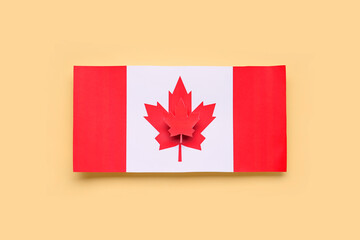 Paper flag of Canada with maple leaf on yellow background