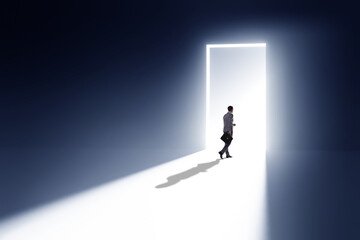 Businessman entering backlit door in escape concept - obrazy, fototapety, plakaty