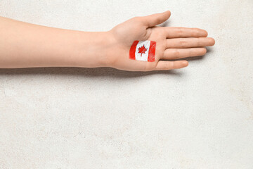Female hand with drawn flag of Canada on white background