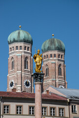 Fototapeta na wymiar Münchner Frauenkirche mit Marienfigur im Vordergrund.