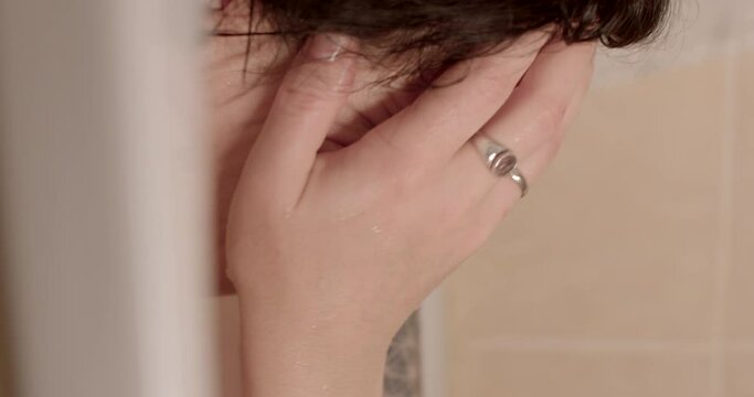 Portrait of a woman with wet face, smeared eyes. She closes her hands, living the emotions of depression. Restoration of mental health in the bathroom. Strong inner experience. Generative AI