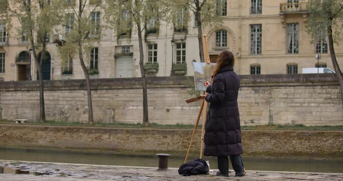 Female street art painter has some sketch practice with Paris city landscape. Experienced European woman artist draws new painting near the river. Painter and her lifestyle hobby leisure Generative AI