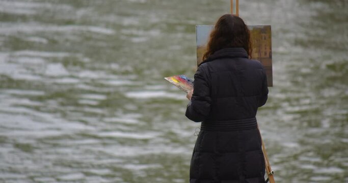 Female street art painter has some sketch practice with Paris city landscape. Experienced European woman artist draws new painting near the river. Painter and her lifestyle hobby leisure Generative AI
