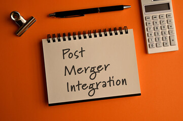 There is notebook with the word Post Merger Integration.It is as an eye-catching image.