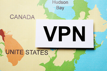 Paper sheet with acronym VPN (Virtual Private Network) on world map, flat lay