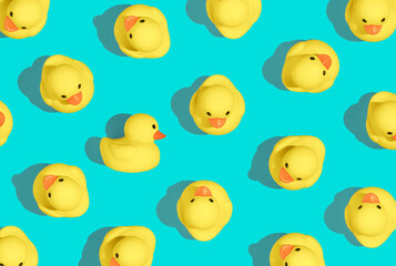 Creative pattern of yello cute rubber duckies on pastel blue background and summer sun with sharp shadows. Minimal concept of Summer Ducks. Creative art, Contemporary style, minimal esthetic