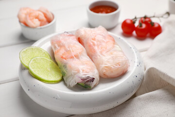Delicious spring rolls with shrimps wrapped in rice paper on white wooden table, closeup