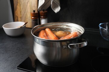 Boiling carrot and potatoes in pot on electric stove. Cooking vinaigrette salad