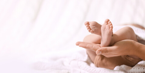 Mother and her baby baby on white knitted blanket, closeup. Banner design with space for text