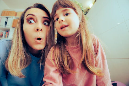 Mother and Little Toddler Girl Trying to Take Silly Selfies. Mom her daughter playing with a camera