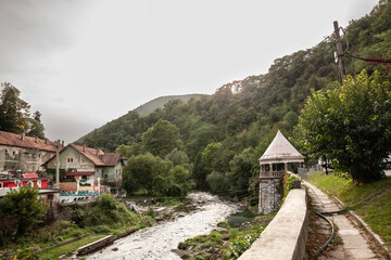 Panorama of the river Cerna in Baile Herculane, Romania, with individual houses and spa and thermal baths in the middle of the mountains in the romanian countryside.