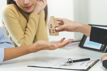 Realtor agent giving a home model to new owner after signed lease agreement.
