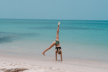 girl doing ring exercise on the beach, gymnastics on vacation, handstand