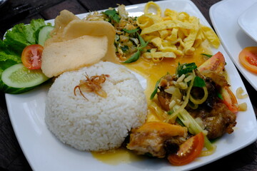 Nasi Campur, nasi rames, Nasi Campur is a dish consisting of vegetable urap, fried chicken, prawn crackers, chili sauce, and stir-fried vegetables. Indonesian food.