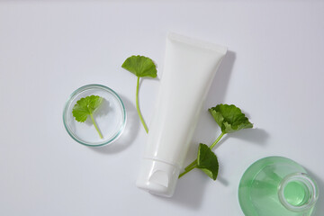 Unbranded tube displayed with a petri dish and an erlenmeyer flask of green liquid extracted from...