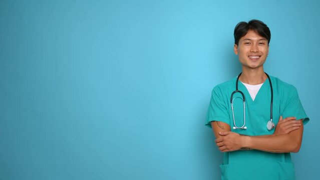 Young man in medical uniform with stethoscope on his neck poses aside smiling and nodding assent folding his arms on his chest, copy space, professional people concept Generative AI