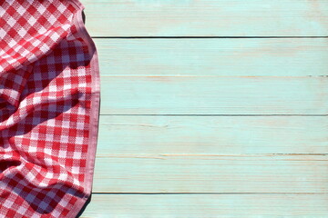 A red checkered napkin lies on a wooden table.