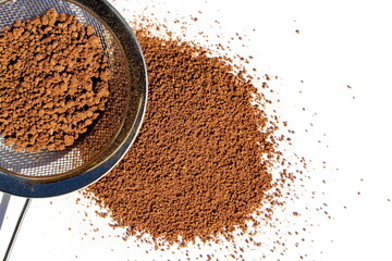 On a white background is cocoa powder with a sieve.